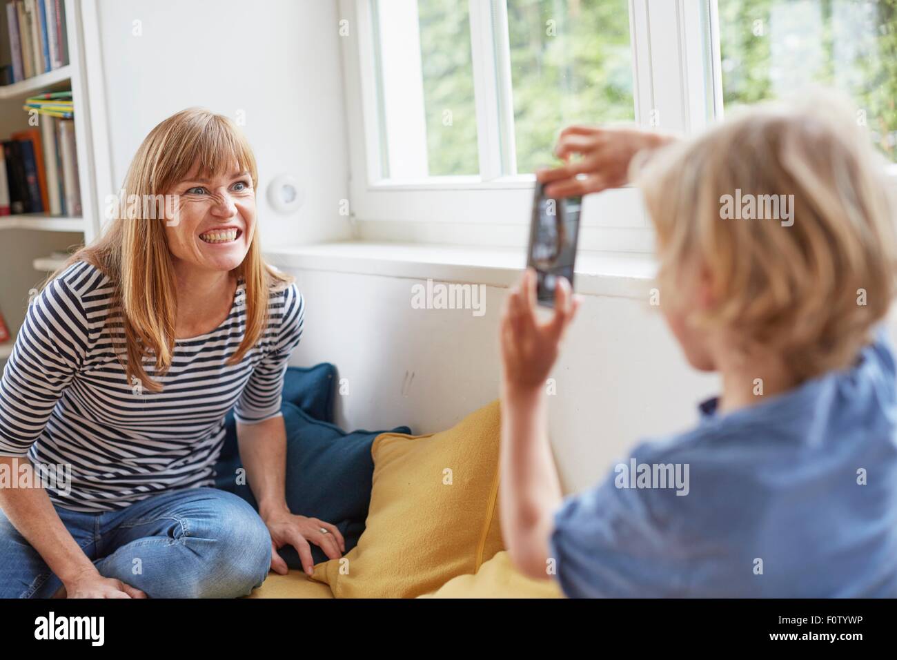 Jeune garçon de prendre photo de mère, using smartphone Banque D'Images