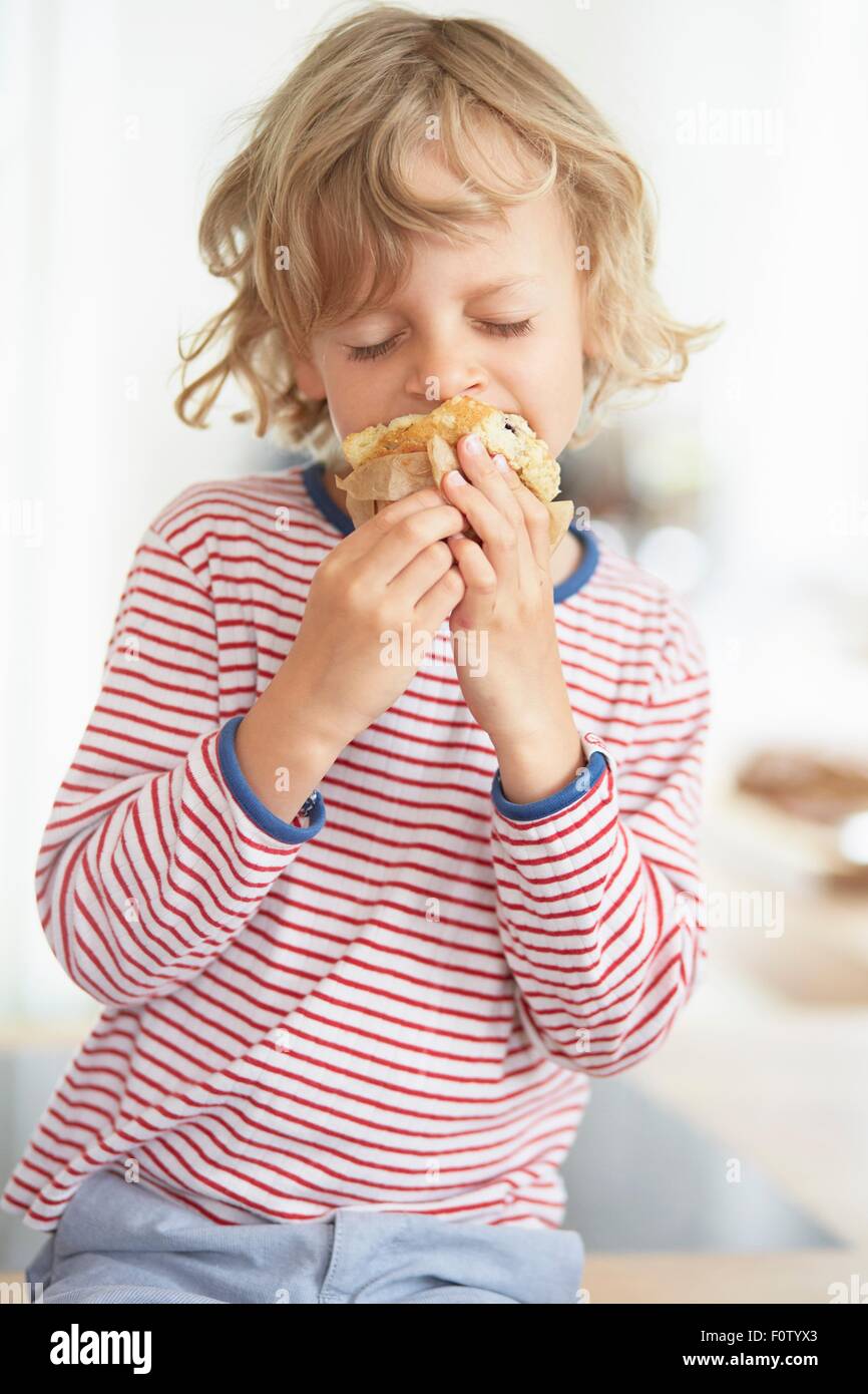 Young boy eating muffin Banque D'Images