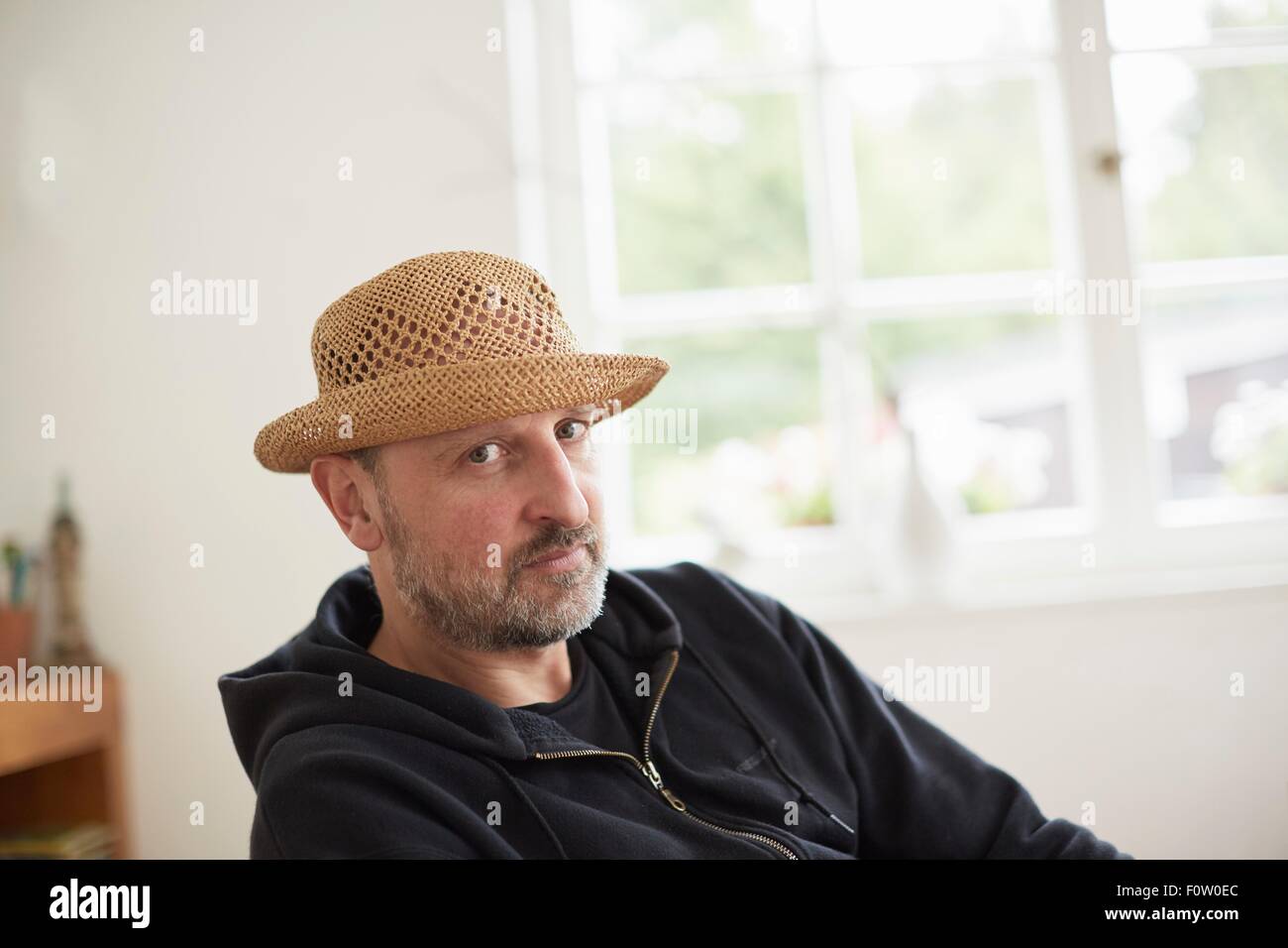 Portrait of mature adult man wearing straw hat, looking at camera Banque D'Images