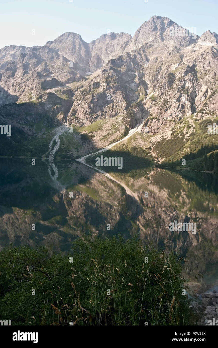 Le lac Morskie Oko dans Szcyt Mieguszowiecki avec montagnes Tatry reflète de pointe sur l'eau la terre pendant le matin d'été Banque D'Images