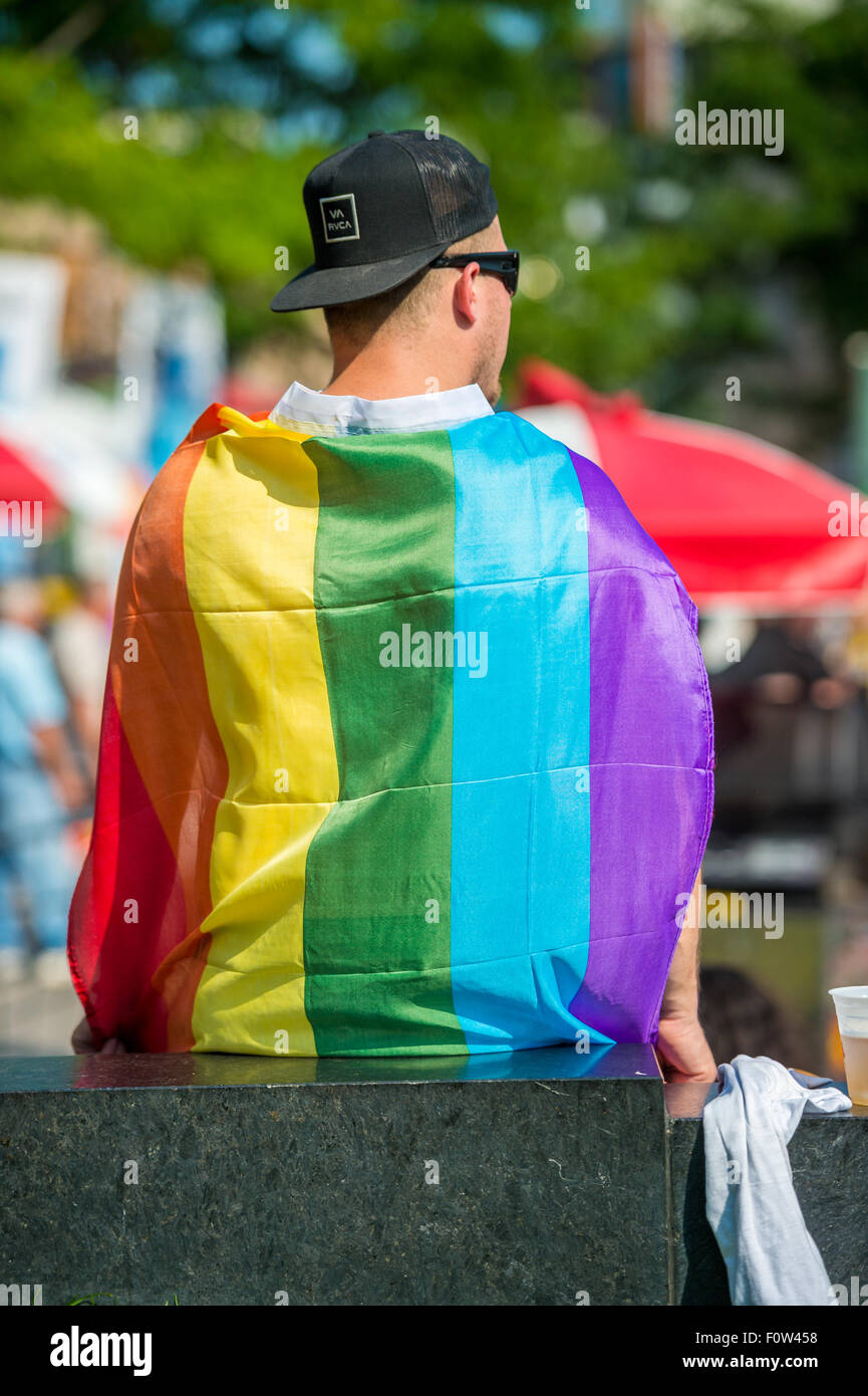 Homme vêtu avec parade gay rainbow flag assistant à la partie après gay pride mars à Montréal Banque D'Images