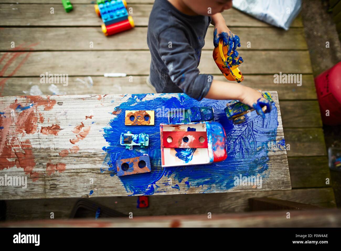 Boy Playing with toy trucks et aquarelle Banque D'Images