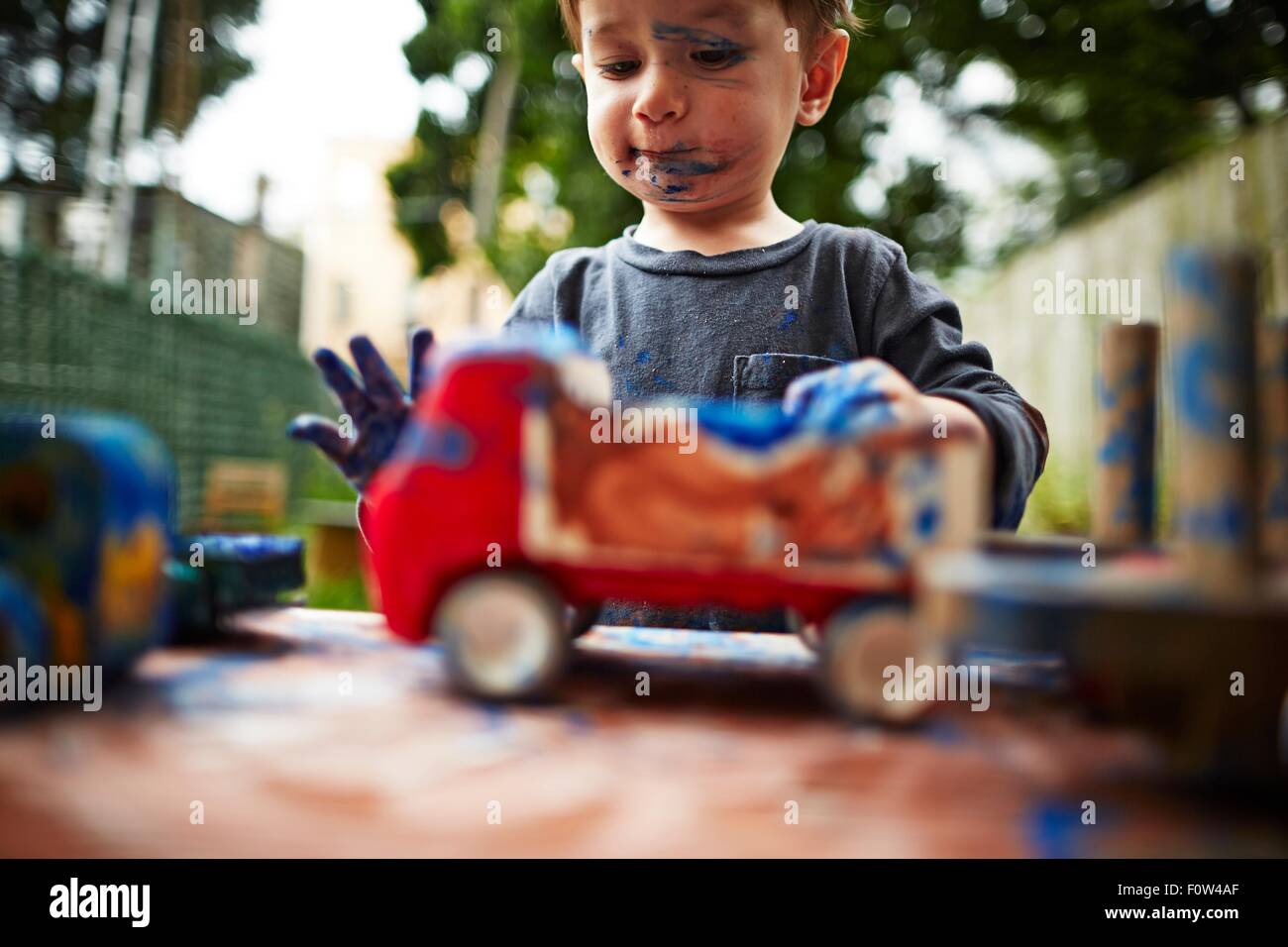 Boy Playing with toy trucks et aquarelle Banque D'Images