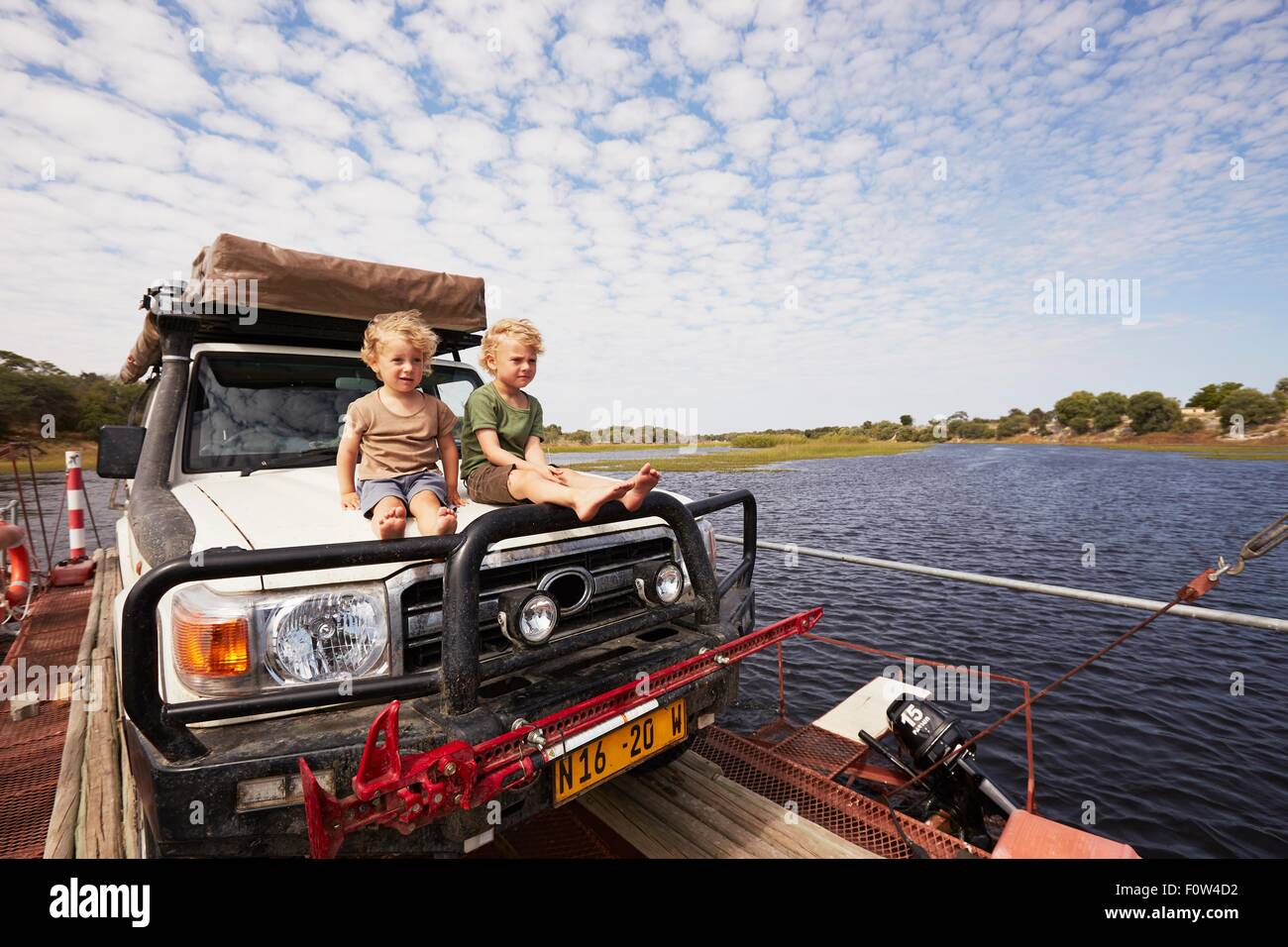 Land cruiser garçons assis sur le capot, Nxai Pan National Park, Botswana Banque D'Images