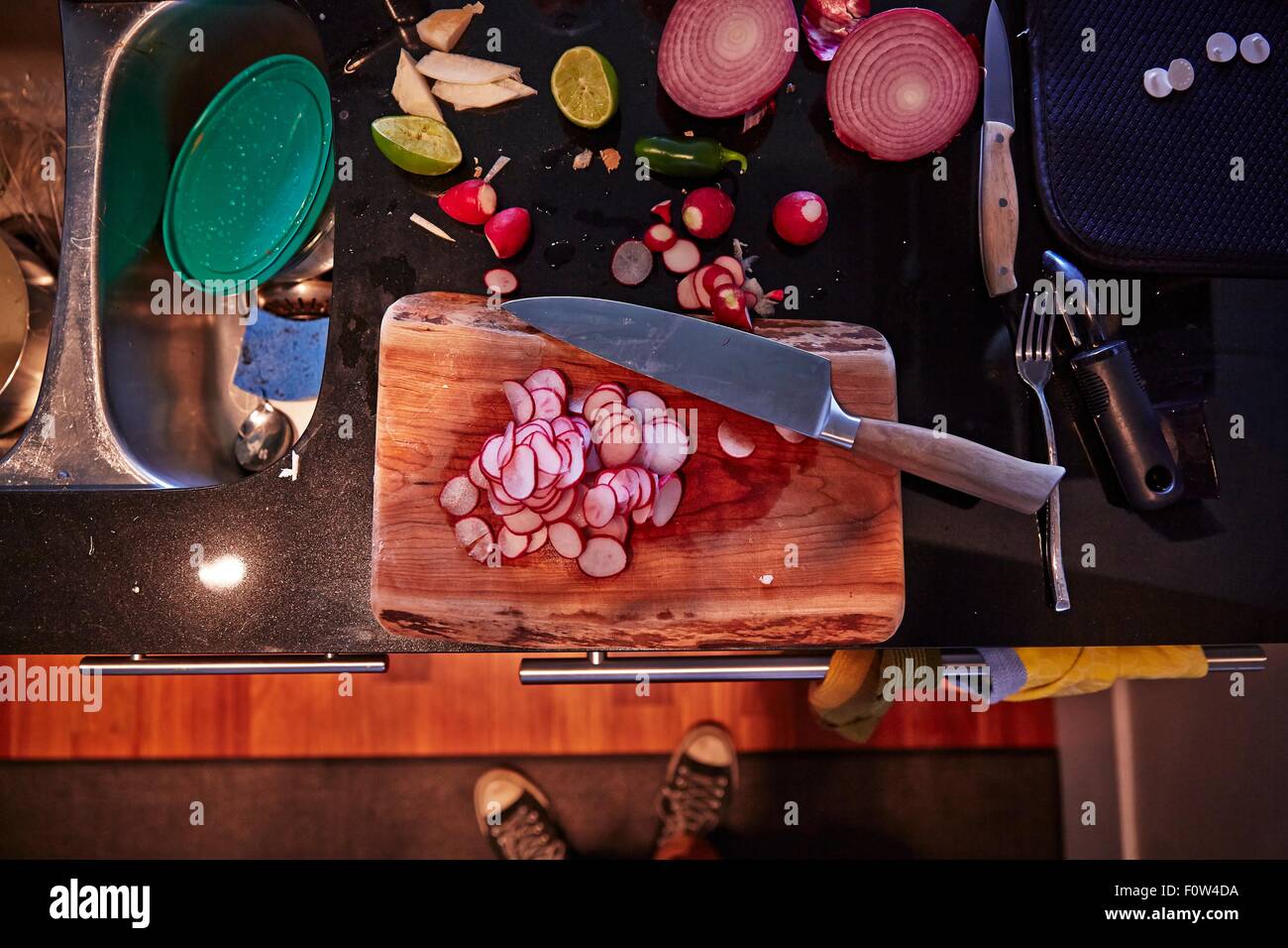 Tranches de radis, l'oignon et les moitiés de chaux, planche à découper et couteau Banque D'Images