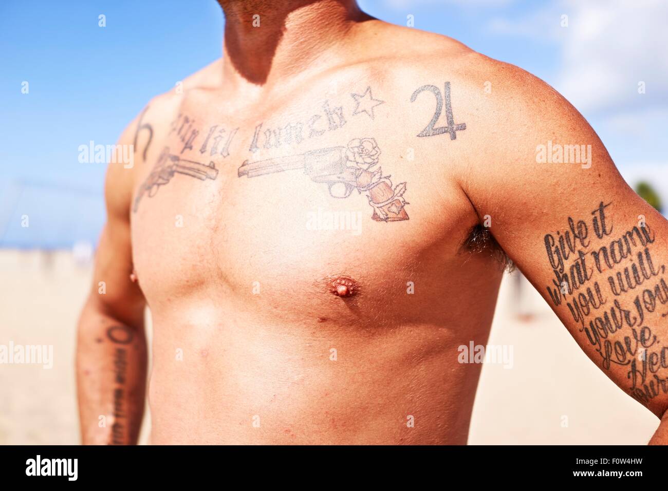 Semi-homme nu avec des tatouages sur la poitrine et les bras Banque D'Images