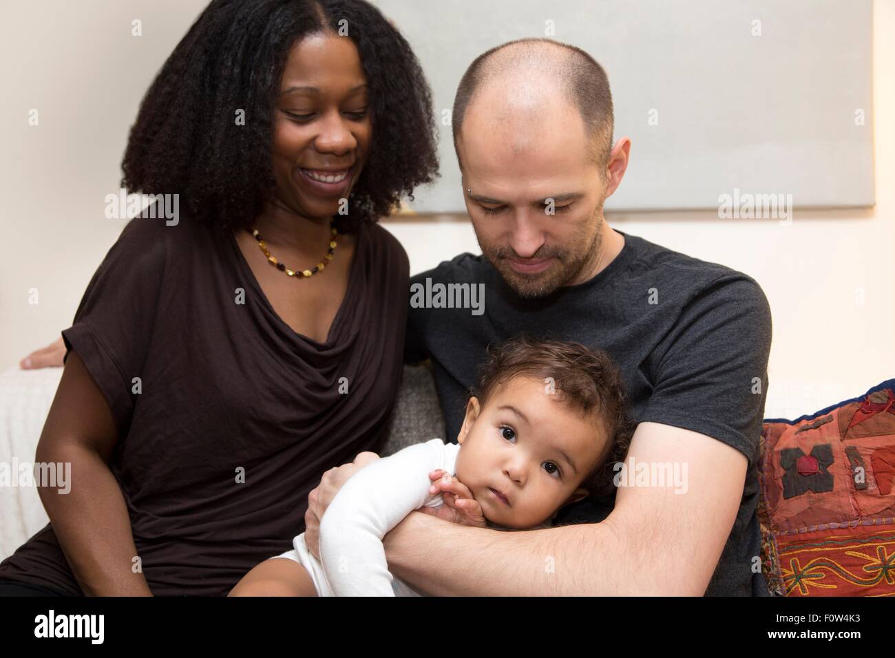 Portrait of mid adult parents et enfant fille sur canapé Banque D'Images