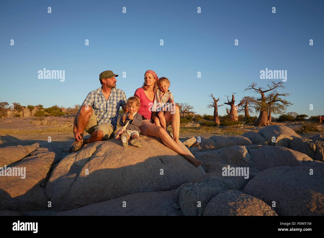 Family sitting on assis sur la roche, looking at view, Gweta, makgadikgadi, Botswana Banque D'Images