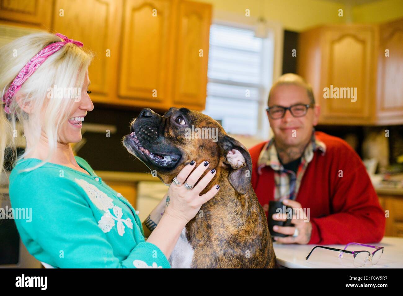 Young woman smiling at boxer dog, face à face Banque D'Images