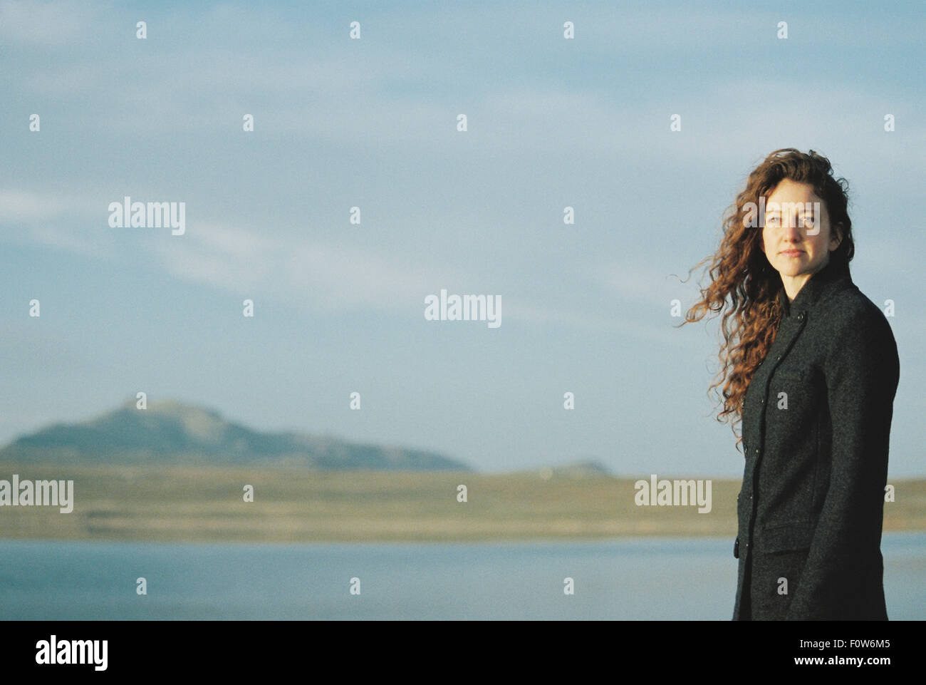 Une femme debout sur le bord d'un lac. Banque D'Images Une femme debout sur le bord d'un lac. Banque D'Images