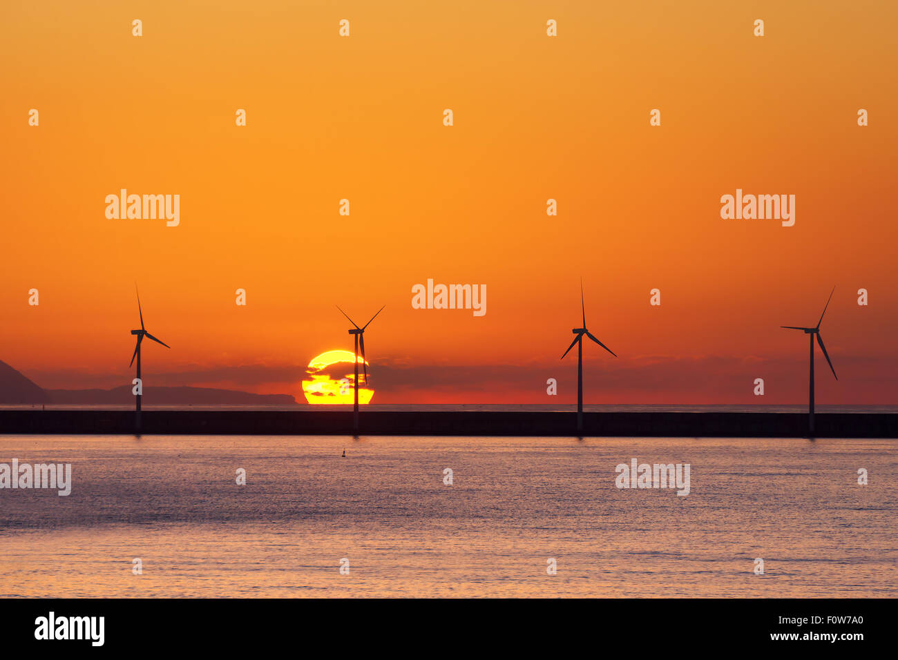 Les éoliennes en mer au coucher du soleil Banque D'Images