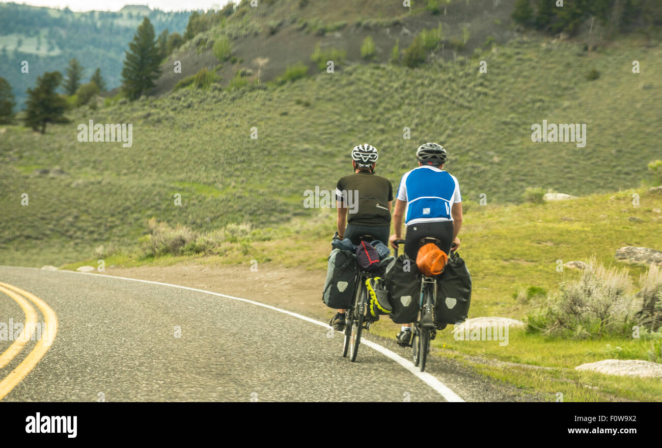 Les motards colportant des vélos avec packs sur la route dans la vallée de Lamar, Yellowstone National Park, Wyoming, USA Banque D'Images