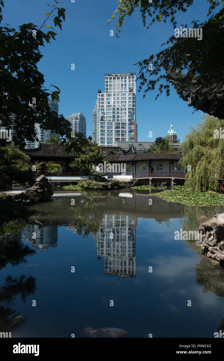 Reflet de hi-rise buinding dans l'eau immobile du Dr. Sun Yat-Sen Classical Chinese Garden, Vancouver Banque D'Images