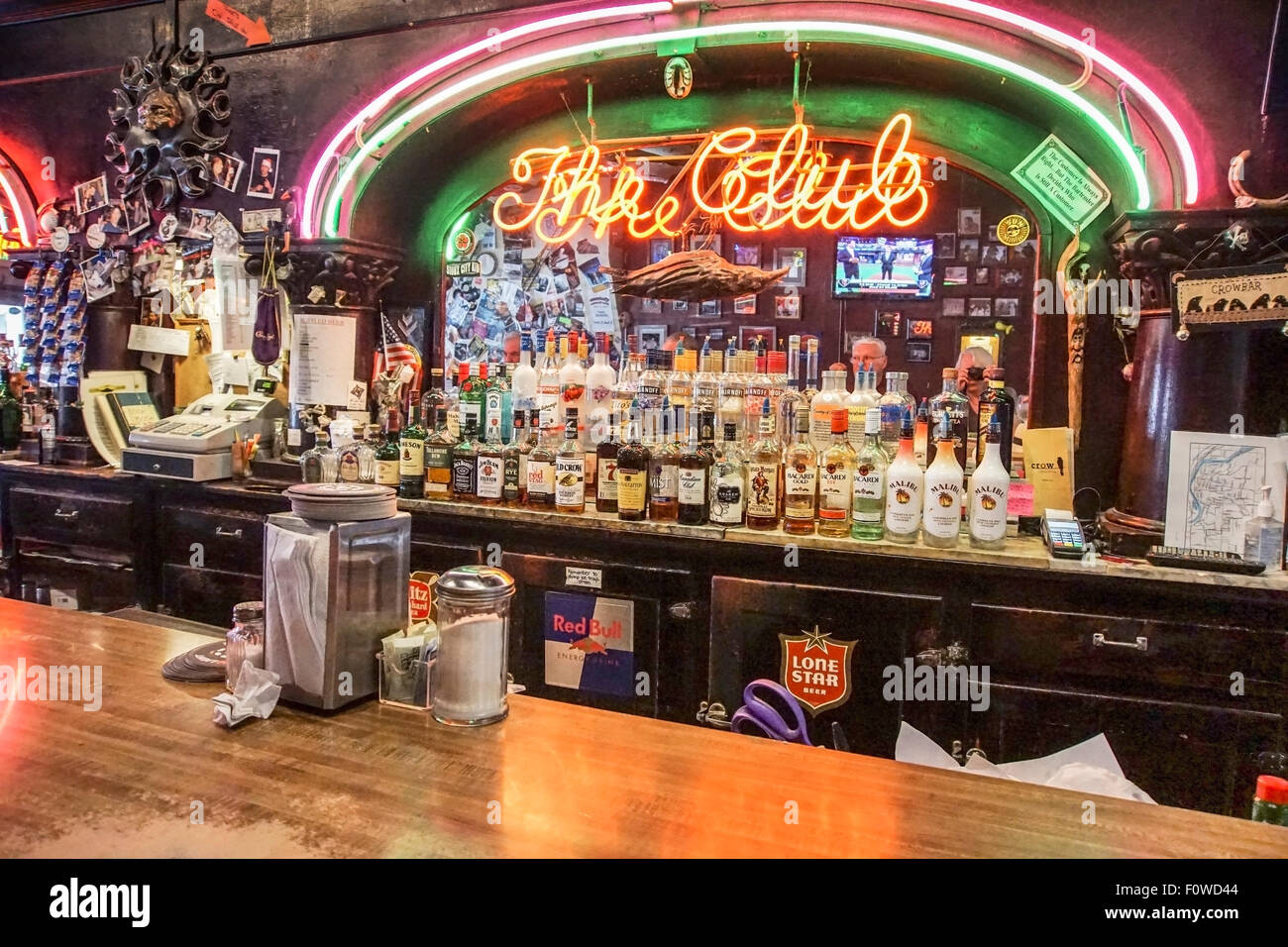 Néon lumineux colorés & arches sculptées avec une signalisation corneille morte pendre sur l'affichage de la liqueur en bouteille disponible à l'ancien bar funky Banque D'Images