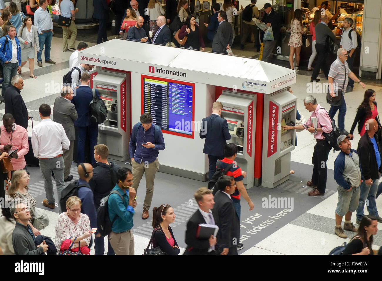 Les banlieusards de l'heure de pointe par l'achat de billets en utilisant les distributeurs de billets dans le hall de la gare de Liverpool Street. Banque D'Images