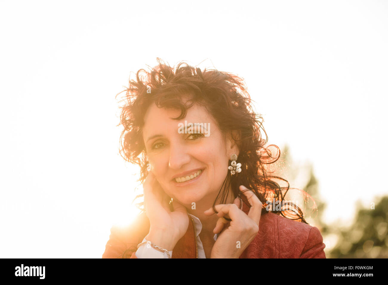 Portrait of smiling senior woman in red jacket à profiter de la vie avec en arrière-plan Banque D'Images