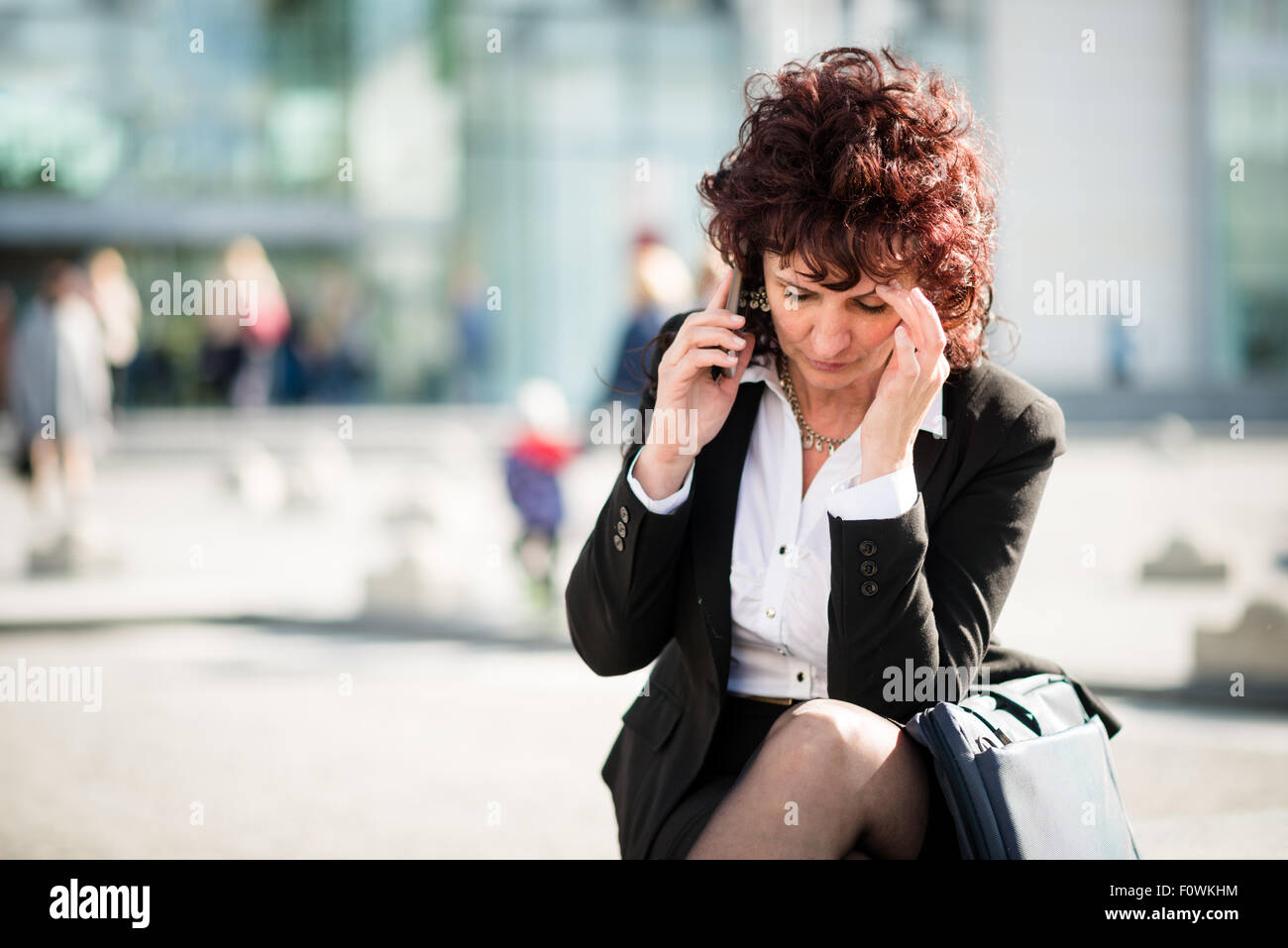 Senior business woman avec maux de tête en plein air téléphone appelant street Banque D'Images