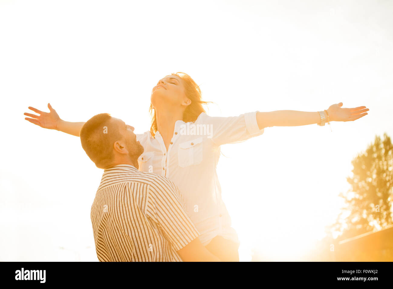 Heureux couple enjoing vie ensemble - photographié au coucher du soleil contre le soleil Banque D'Images