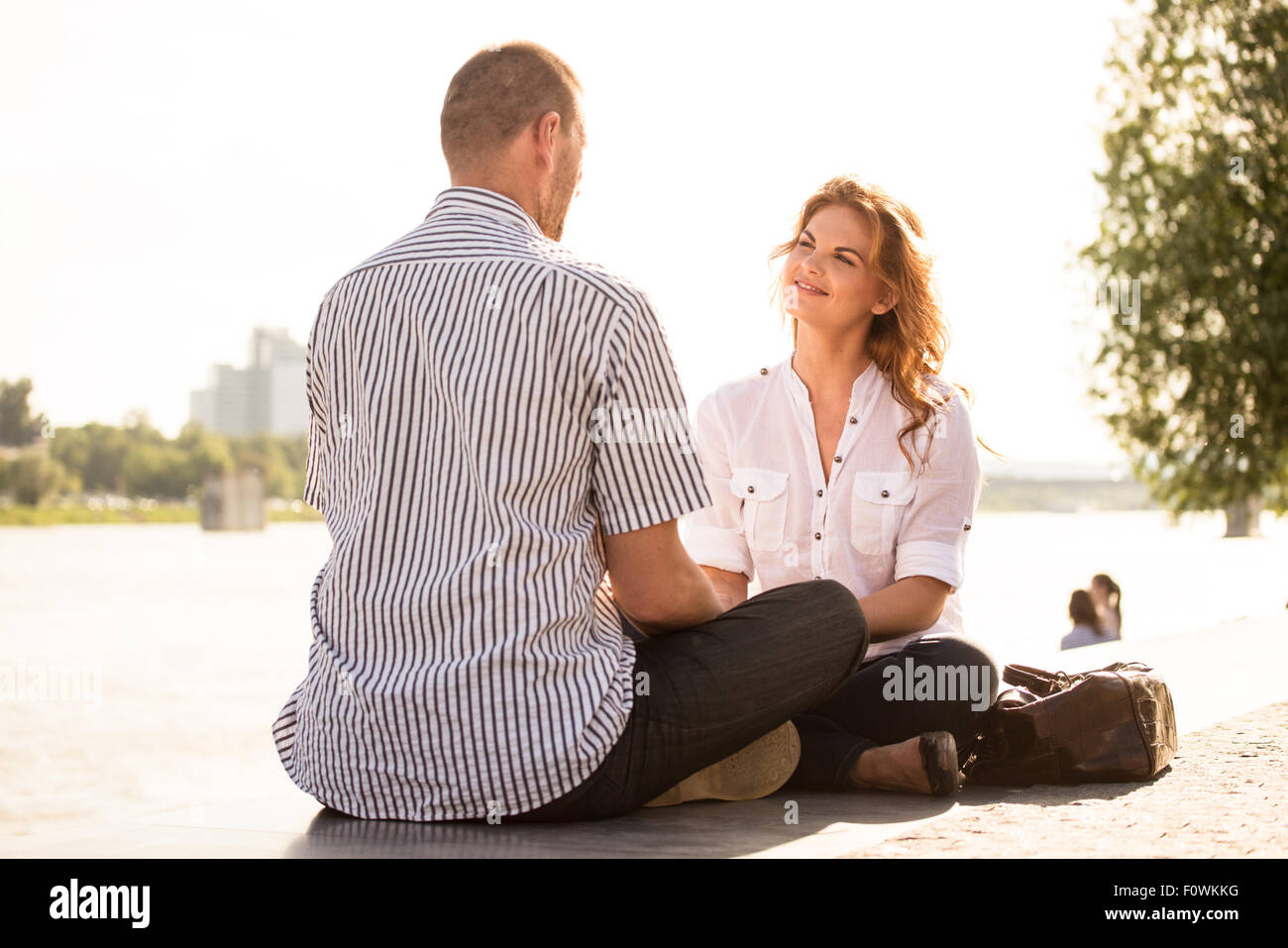 Jeune femme parlant à une date avec man - sitting outdoors Banque D'Images