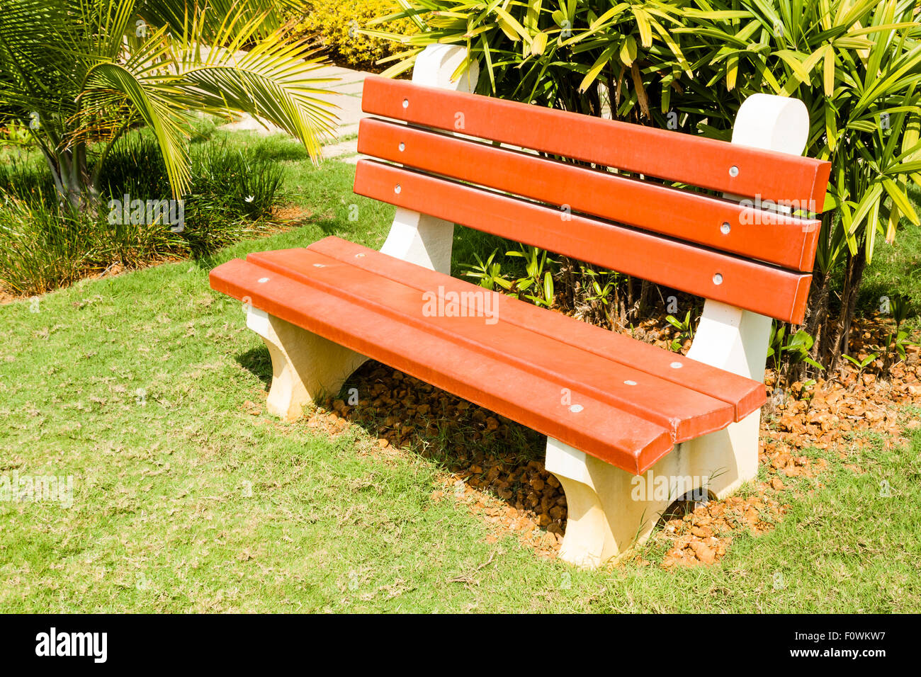 Banc en béton dans un parc tourné sur une journée ensoleillée. Banque D'Images