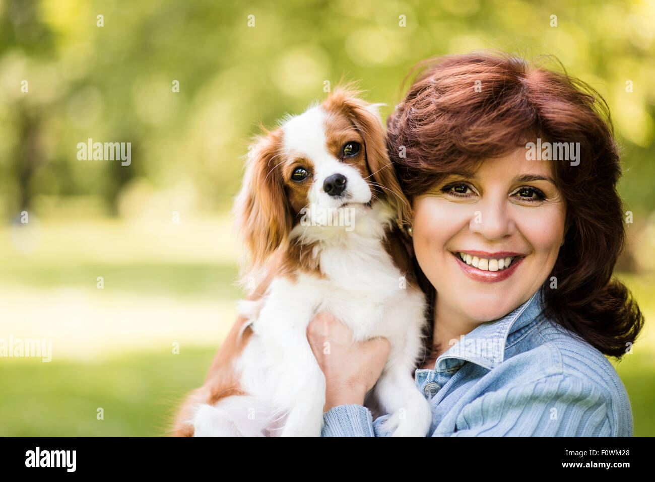 Portrait de femme mature avec son chien cavalier dans la nature Banque D'Images