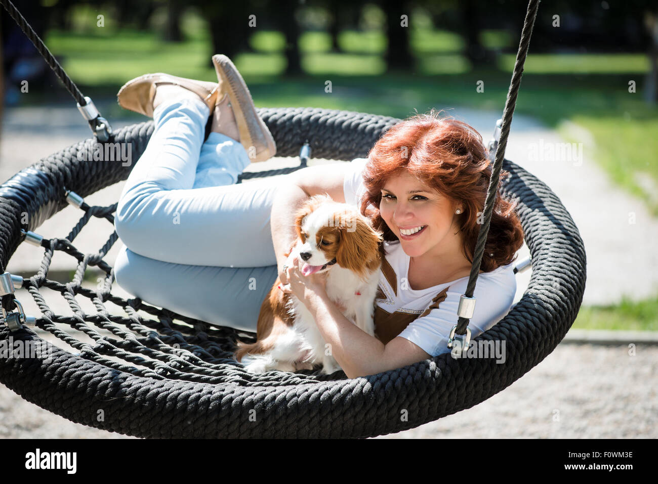 Femme mature avec son swing en plein air aire de chien cavalier Banque D'Images