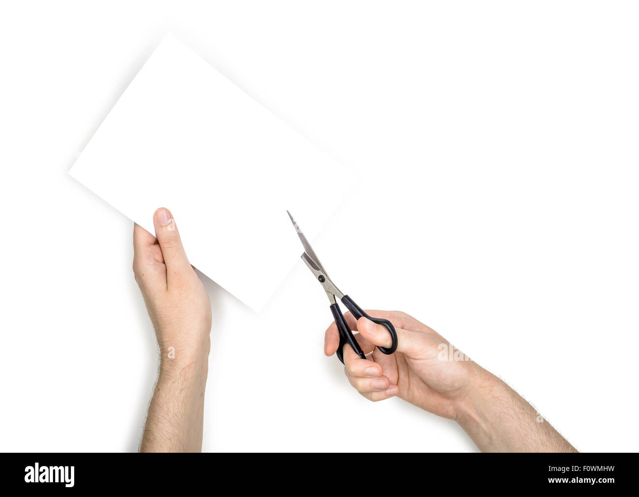 Une femme est couper une feuille de papier blanc à l'aide de ciseaux métalliques, isolé sur fond blanc Banque D'Images