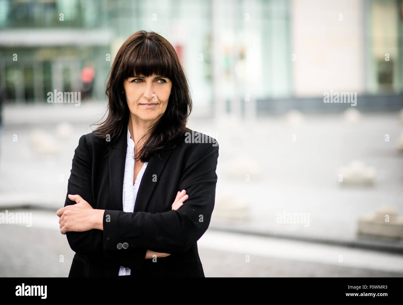 Street portrait de senior business woman standing with crossed mains Banque D'Images
