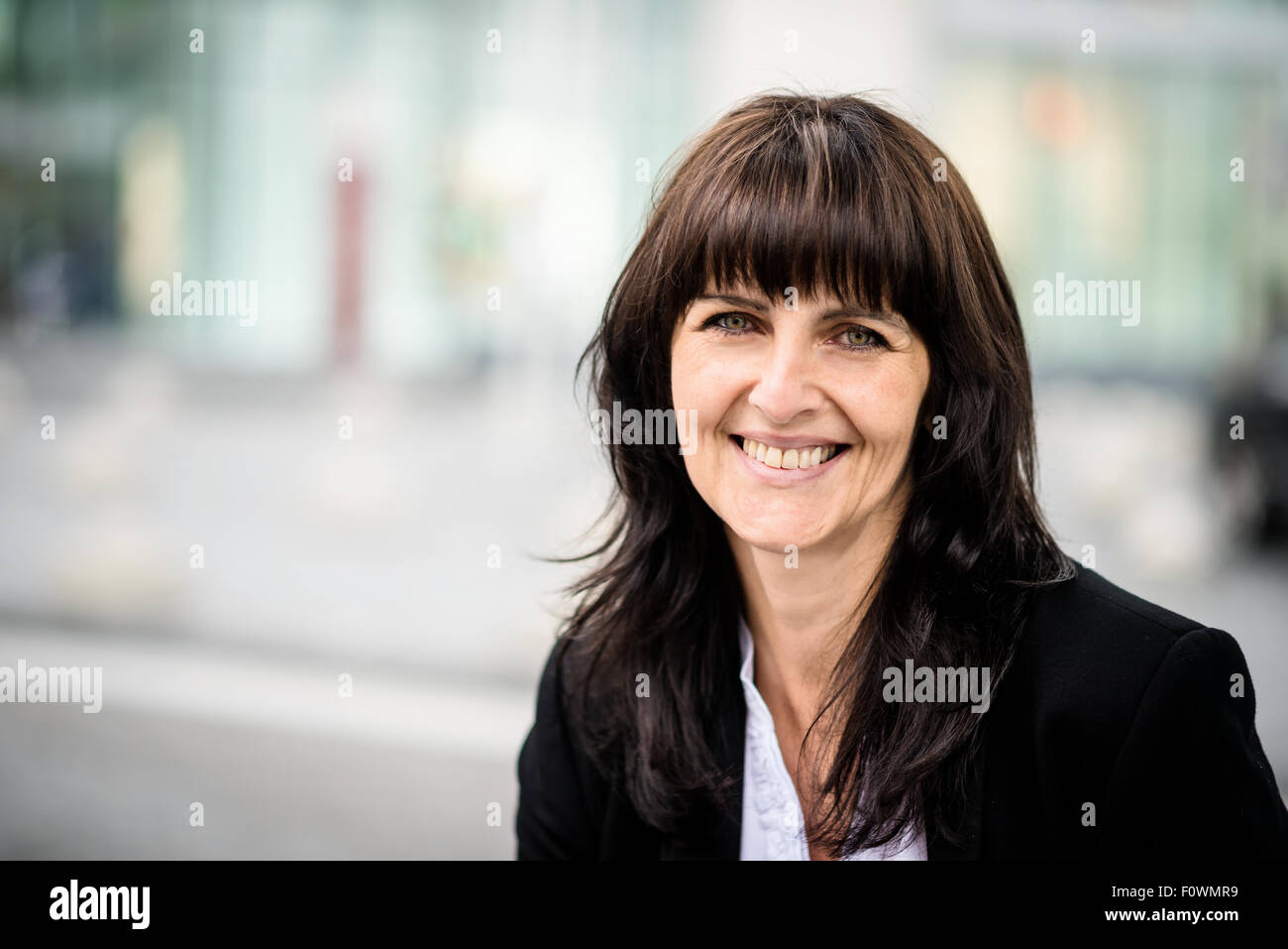 Senior business woman avec office building en arrière-plan Banque D'Images