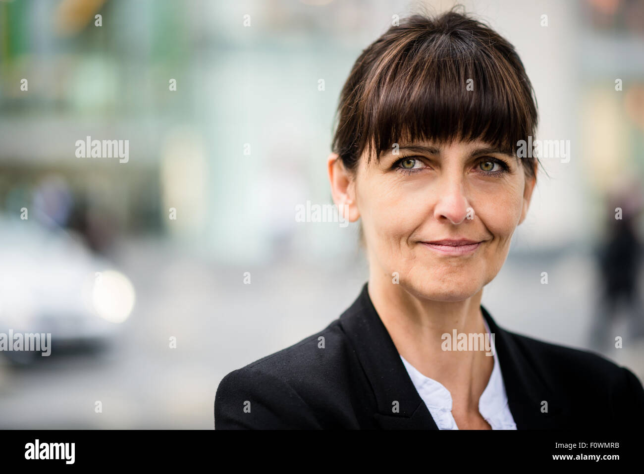 Outdoor portrait of smiling confiant senior business woman looking away Banque D'Images