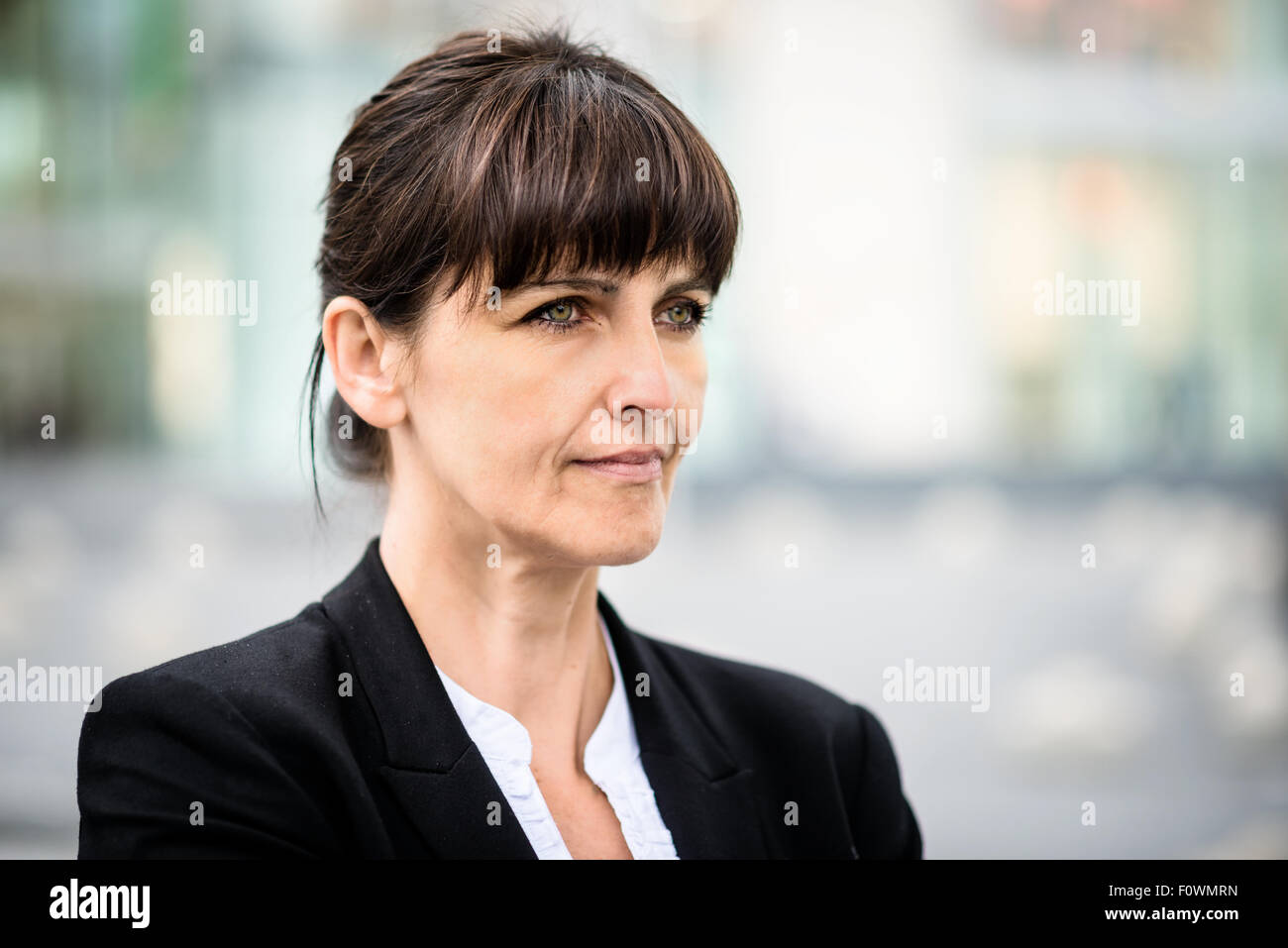 Exteriorportrait de sourire confiant senior business woman looking away Banque D'Images