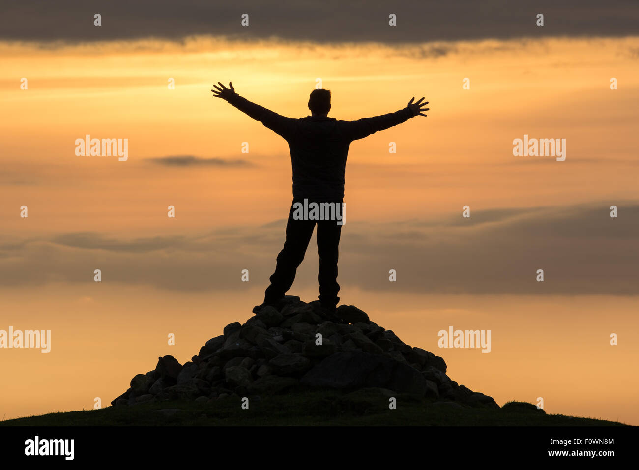 Grand, haute silhouette d'un homme au sommet d'une montagne Banque D'Images