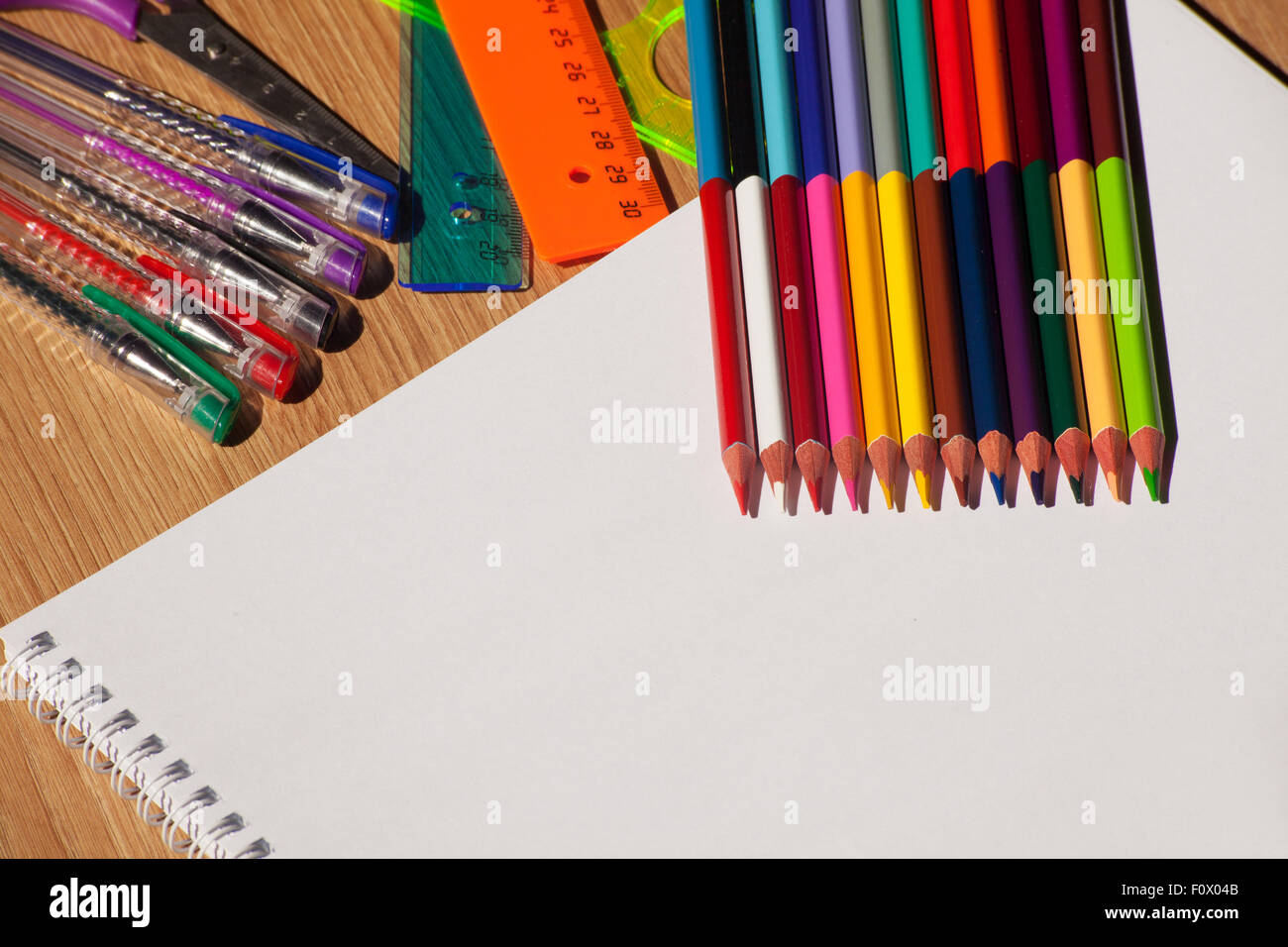 Des crayons, des stylos, des dirigeants avec un ordinateur portable blanc sur la table en bois Banque D'Images