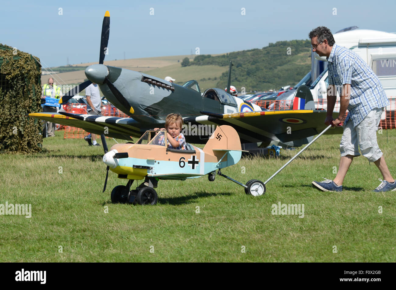 Shoreham Airshow 2015. Enfant qui est poussé par des profils dans la Luftwaffe allemande jouet moi109 avion de chasse Banque D'Images