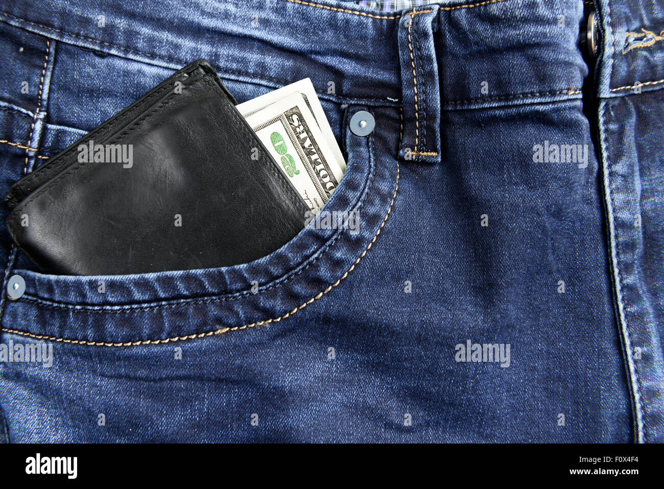 Porte-monnaie avec des dollars dans la poche de jeans Banque D'Images