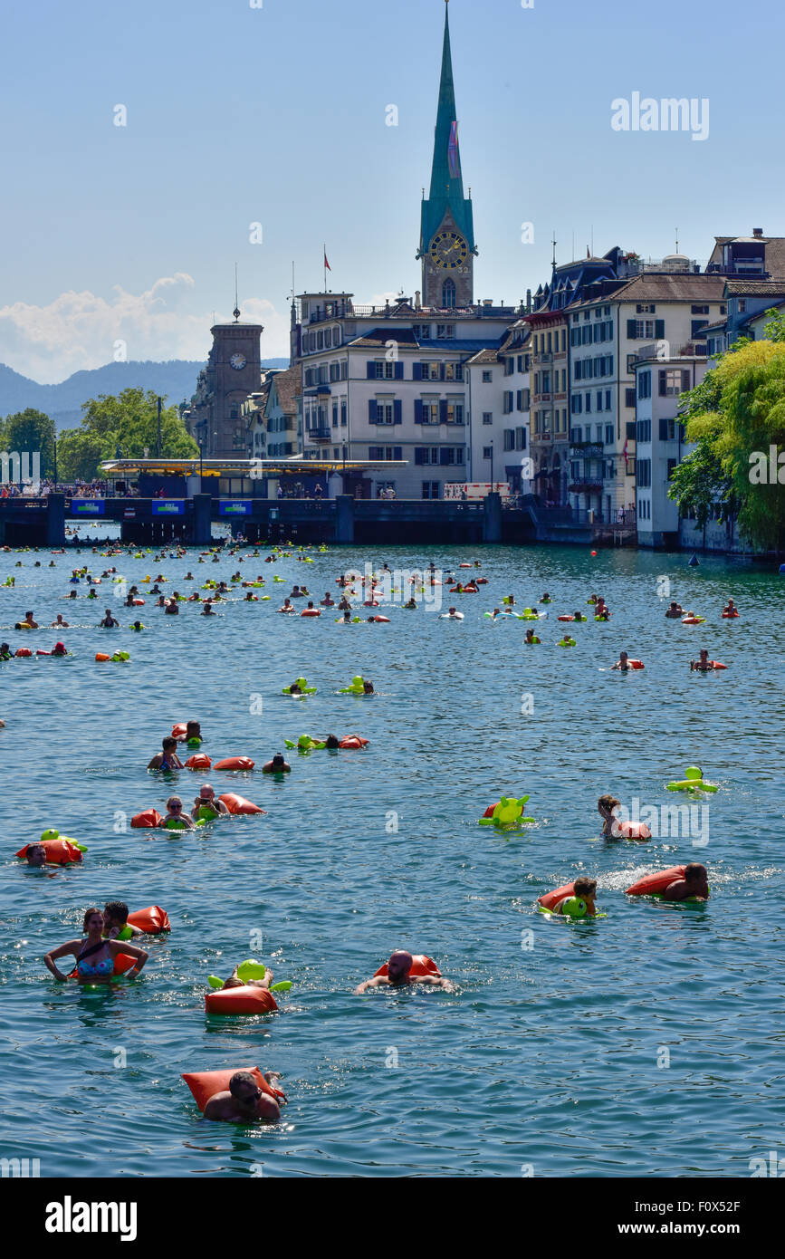 Zurich, Suisse. Le 22 août, 2015. Le temps ensoleillé et les températures chaudes à la Zurich's 'traditionnelle' ('SLimmatschwimmen wim en bas de la rivière Limmat') a attiré 4500 nageurs qui, équipés de tortues en caoutchouc et d'autres dispositifs flottants de fantaisie, apprécié à la dérive le fleuve grâce à Zurich. Dans l'arrière-plan : la vieille ville de Zurich avec l'église Fraumünster. Crédit : Erik Tham/Alamy Live News Banque D'Images