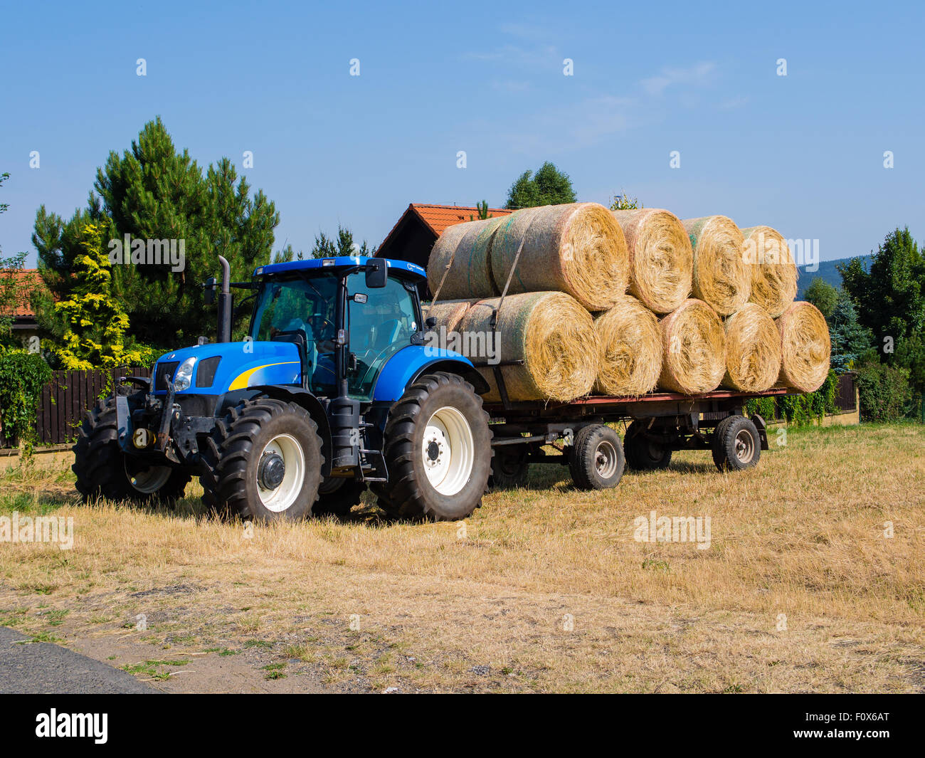 Le tracteur et le wagon chargé avec des meules de foin pendant les moissons Banque D'Images
