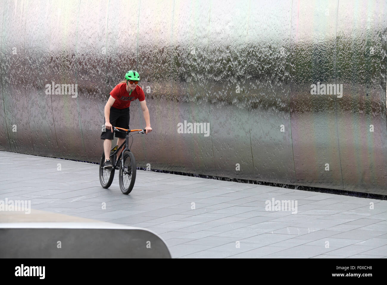 Stunt cyclist en face de la pointe de l'acier sculpture à la gare ferroviaire de Sheffield Banque D'Images