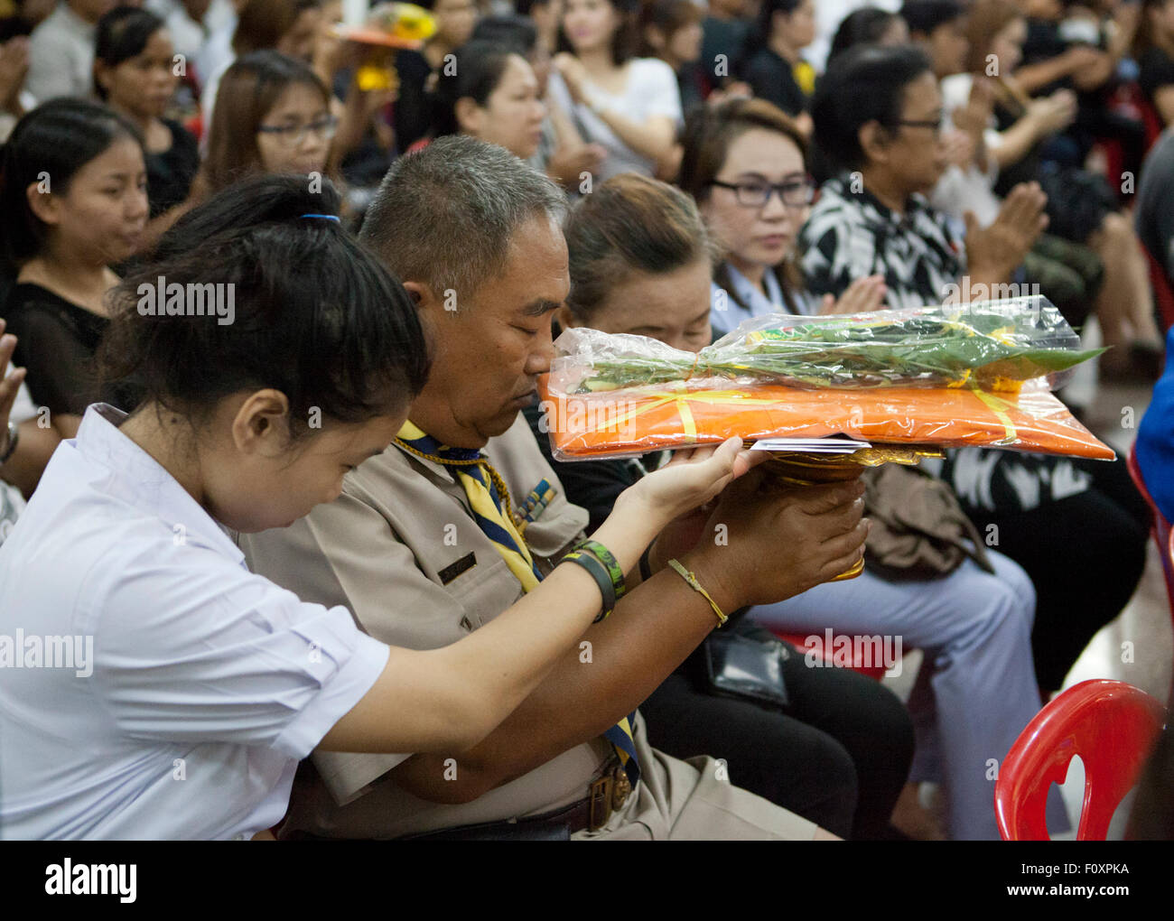 Les gens passent autour de cadeaux pour des moines au cours de services funéraires pour Yutnarong Singro au Wat Bangna Nok à Bangkok. Trois jours après l'explosion d'une bombe tuant près du sanctuaire d'Erawan en Central Chidlom district. Au moins 20 personnes sont mortes et 125 ont été blessés dans l'attaque. Banque D'Images