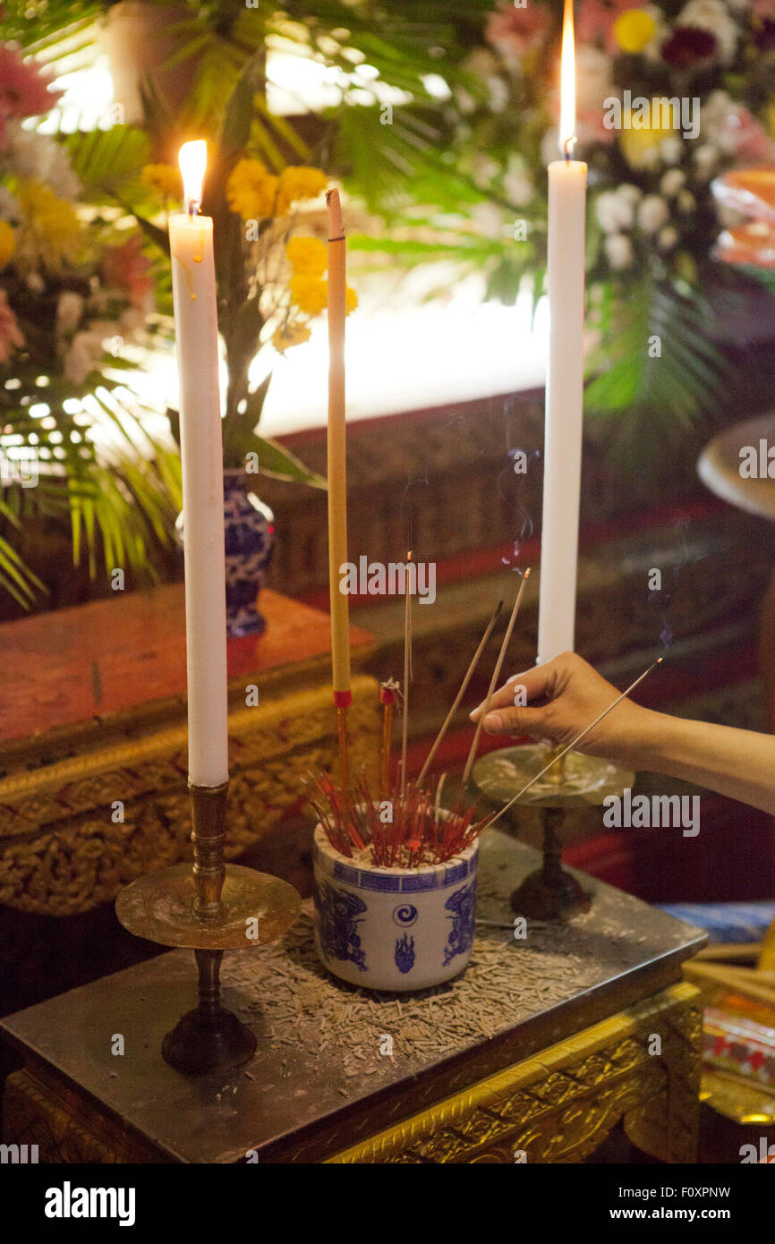 Un homme met un bâton d'encens sur un autel au cours de services funéraires pour Yutnarong Singro au Wat Bangna Nok à Bangkok. Trois jours après l'explosion d'une bombe tuant près du sanctuaire d'Erawan en Central Chidlom district. Au moins 20 personnes sont mortes et 125 ont été blessés dans l'attaque. Banque D'Images