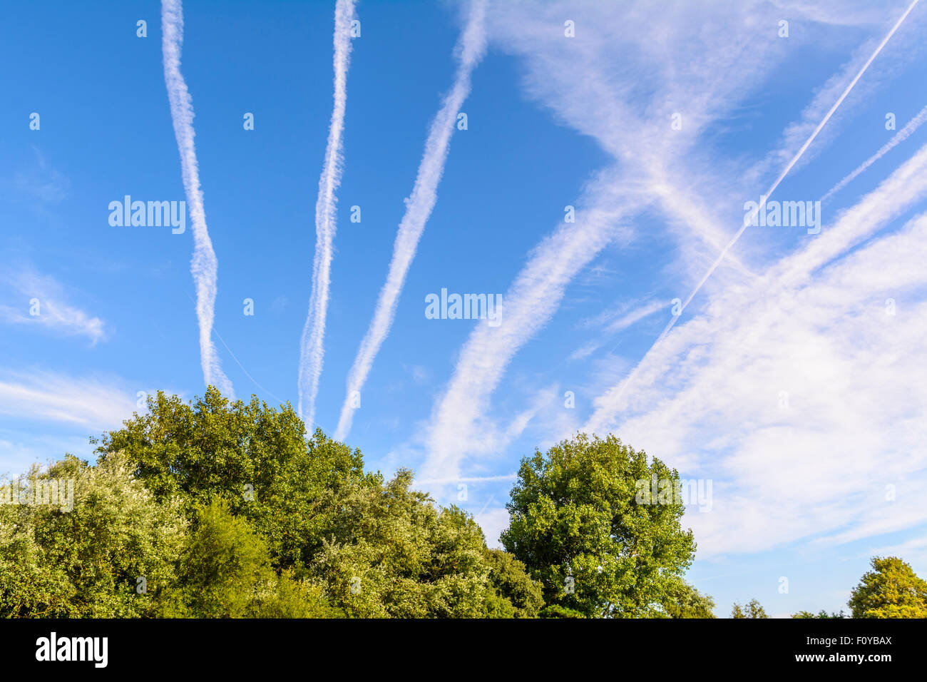 Traînées de condensation trails (vapeur) à partir de moteurs à réaction dans les avions, dans le ciel bleu. Des avions ou de la pollution de l'avion. Le réchauffement climatique. Banque D'Images