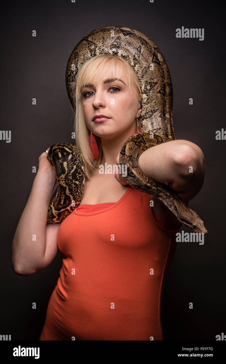 Une jeune femme fille femme posant avec un python serpent enroulé autour de la tête , UK (ne souffre pas d'ophiophobia - la peur des serpents) Banque D'Images