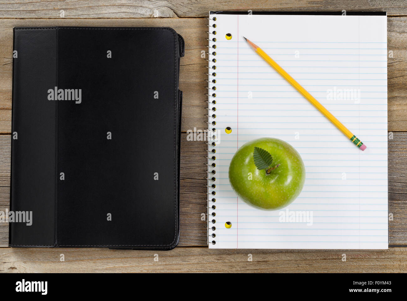 Vue de dessus de la pomme verte, le bloc-notes, bloc-notes et crayon sur bois rustique. Banque D'Images
