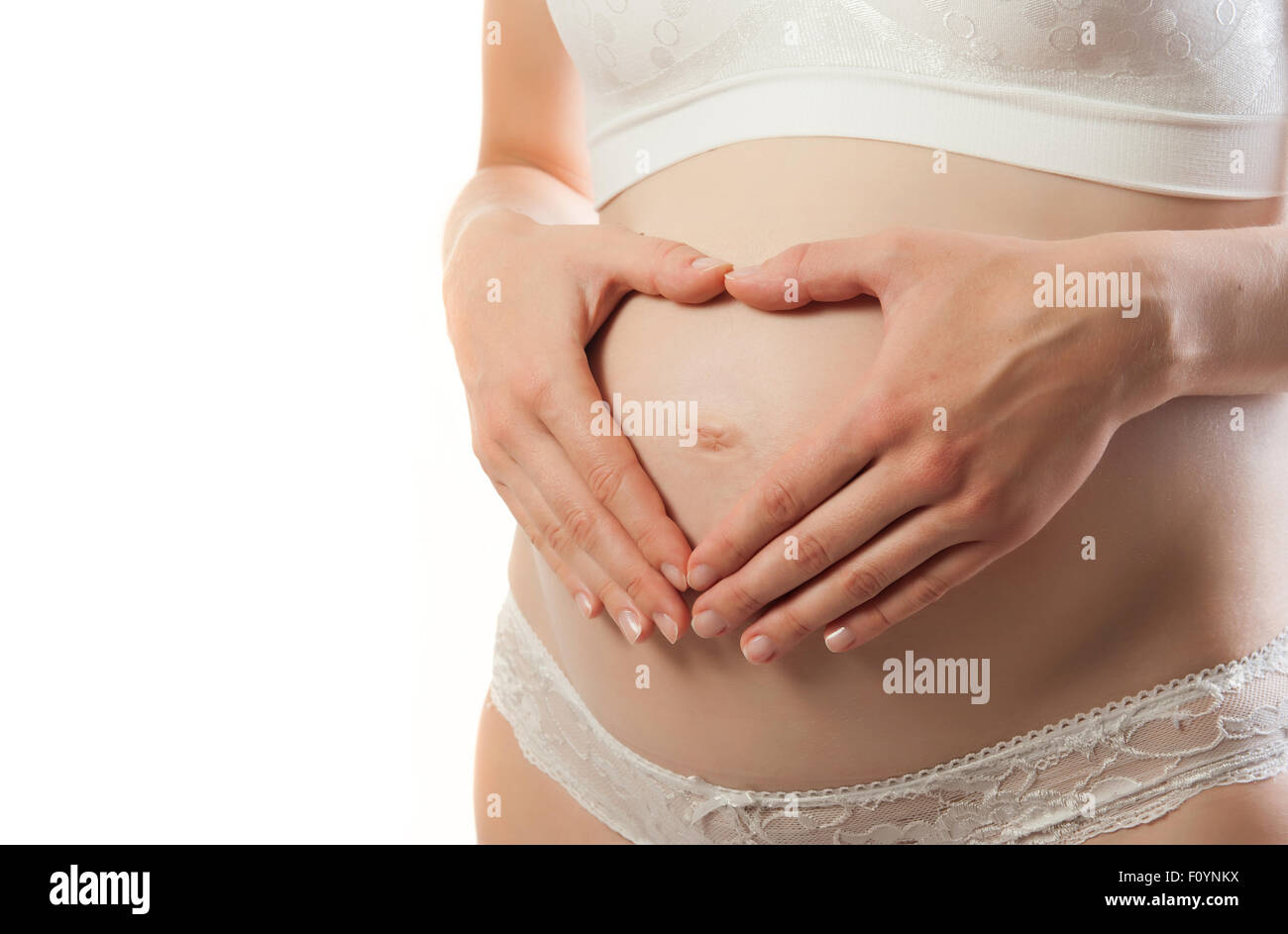 Pregnant Woman holding ses mains en forme de coeur sur son bébé bosse Banque D'Images