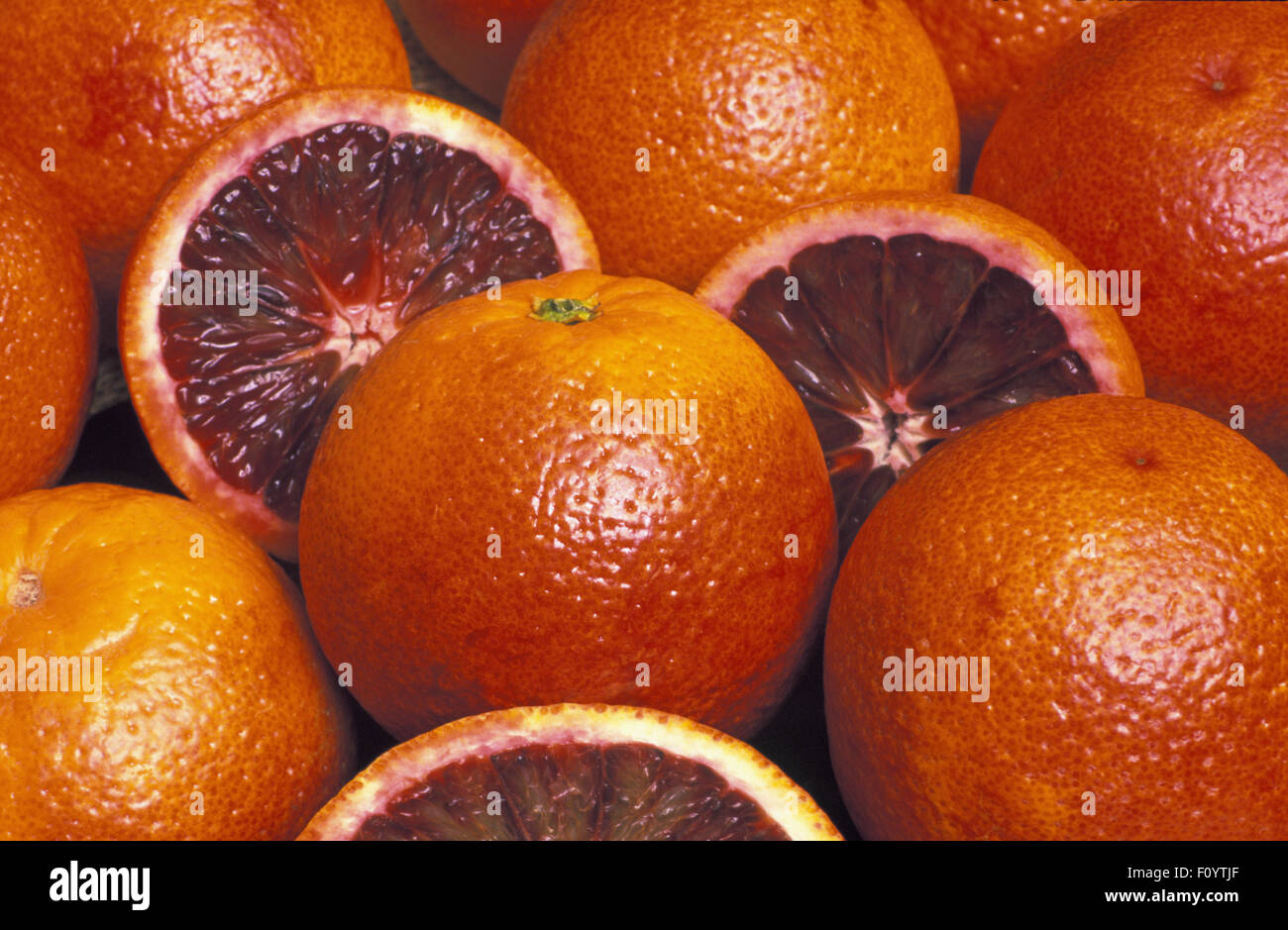 IMAGE STUDIO D'ORANGES SANGUINES ENTIÈRES ET COUPÉES EN DEUX (CITRUS SINENSIS) ÉGALEMENT CONNUES SOUS LE NOM D'ORANGES ROUGES OU PIGMENTÉES, TAROCCO OU SANGUINELLO. Banque D'Images