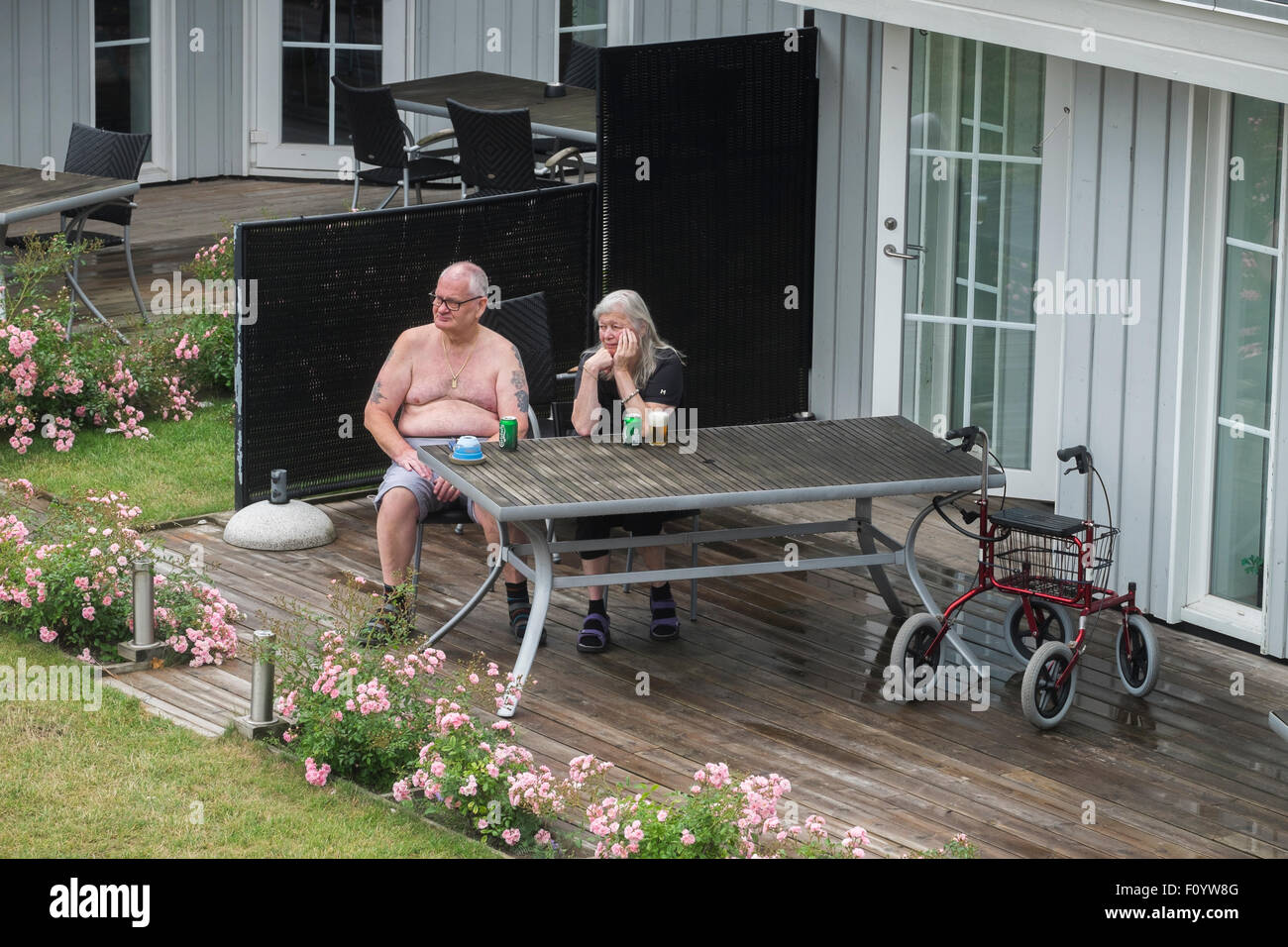 Un couple de personnes âgées assis dehors, boire de la bière Banque D'Images