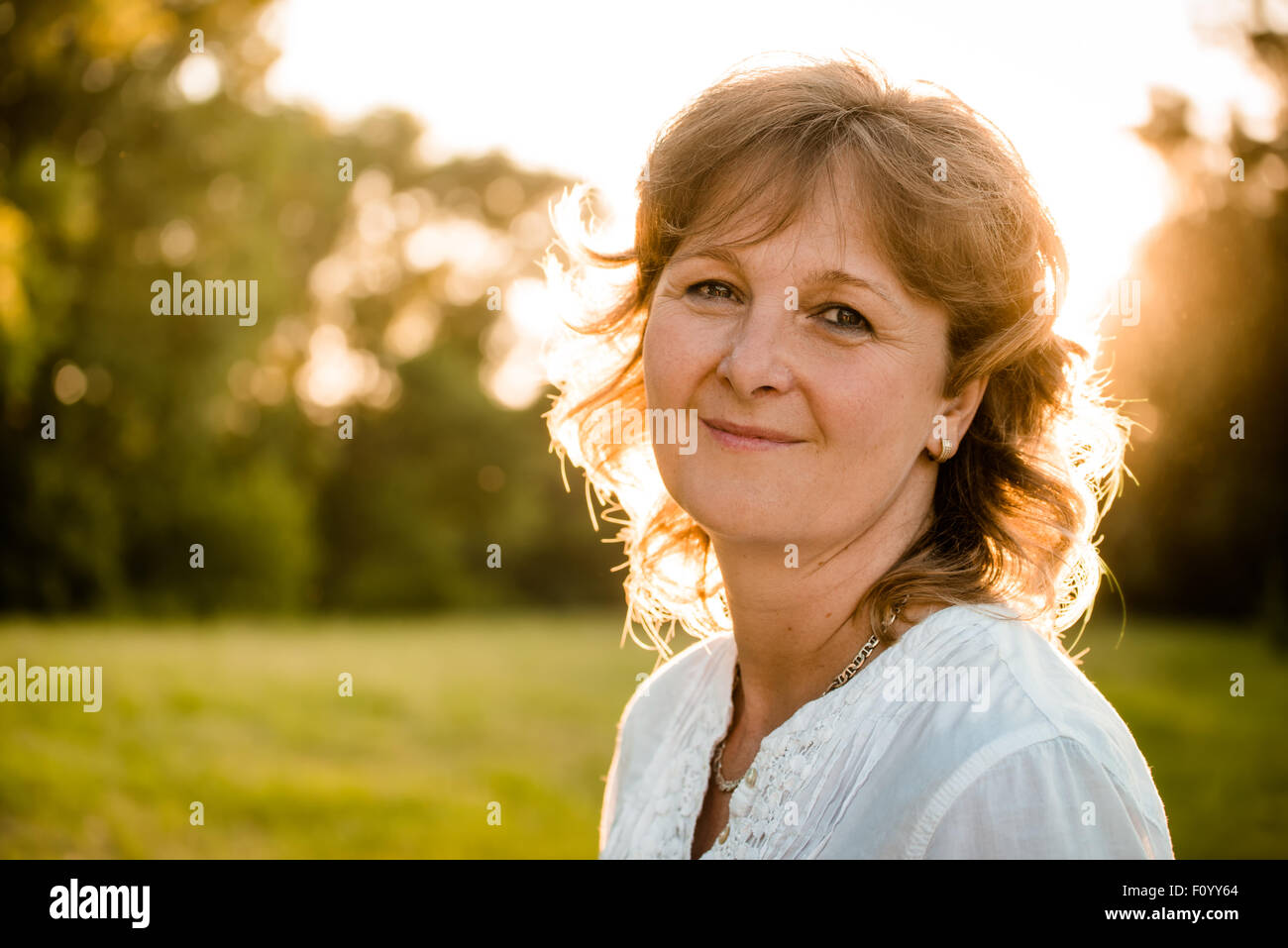 Portrait de femme mature en plein air - dans la nature au coucher du soleil Banque D'Images