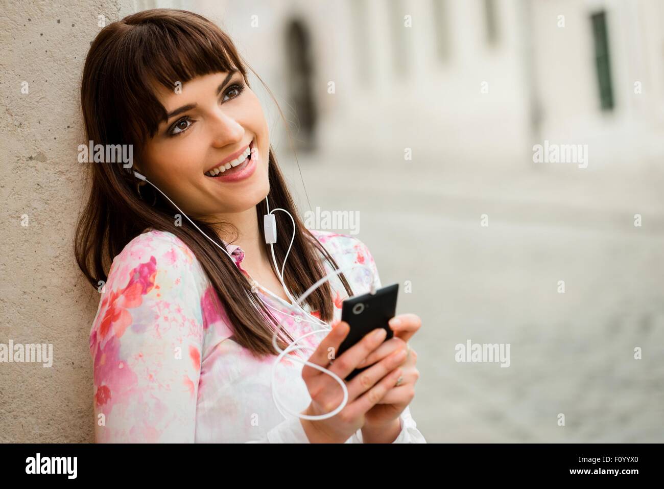 Jeune femme chantant de la musique elle est à l'écoute de votre téléphone mobile en street Banque D'Images