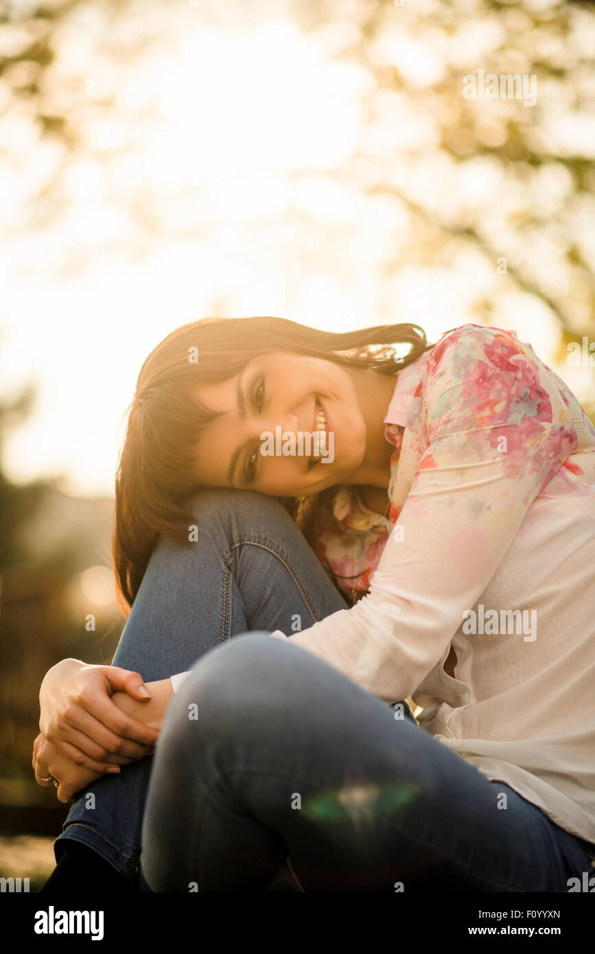 Portrait de femme appuyée sur son genou séance piscine au coucher du soleil Banque D'Images