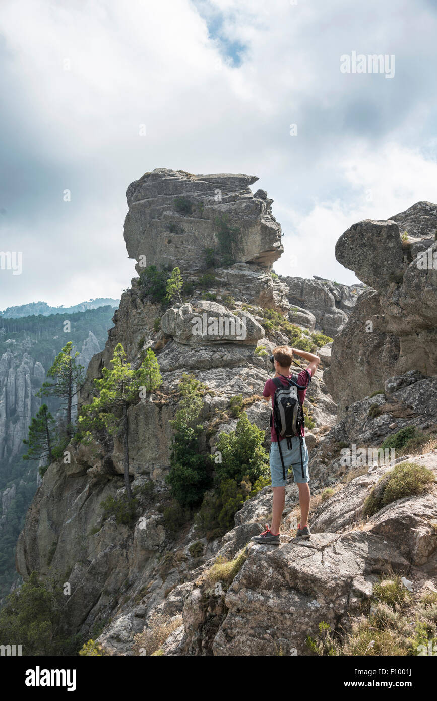 Touriste, young man photographing rock formations, paysage de montagne, l'Ospedale Alta Rocca, Corse, France Banque D'Images
